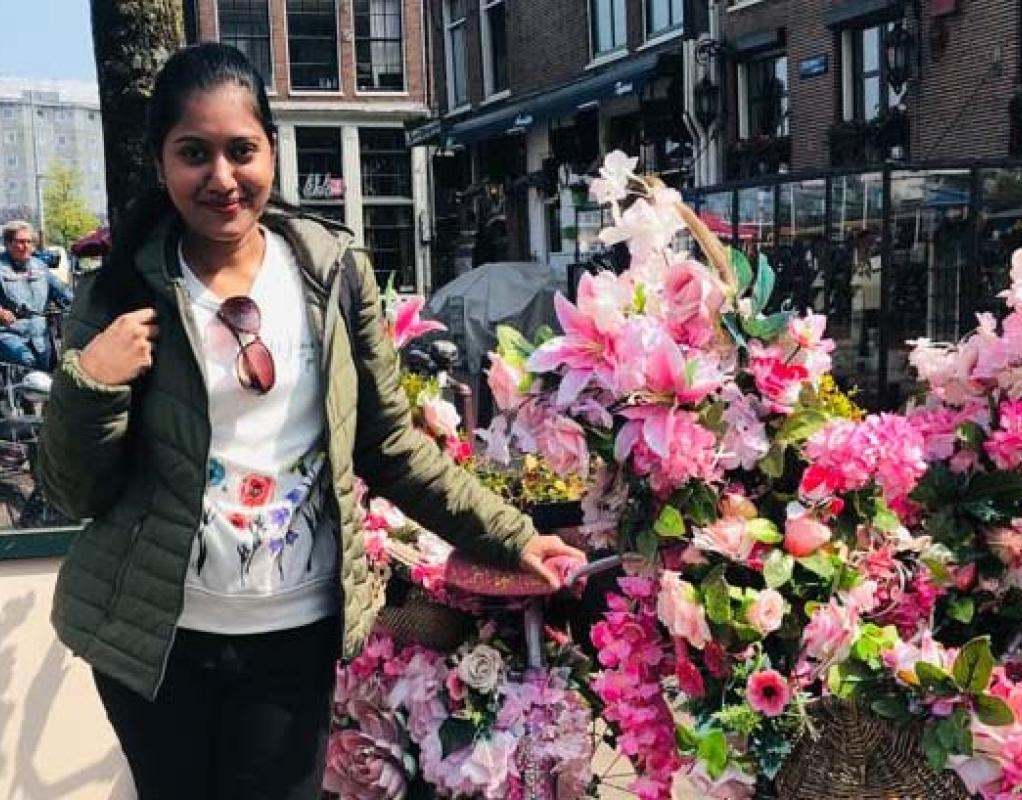 Nipuni standing next to a bike covered in flowers
