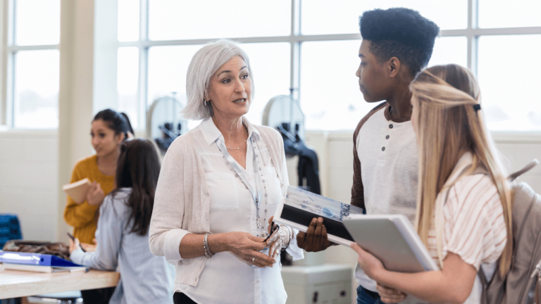 Photo of two students talking to a school counselor